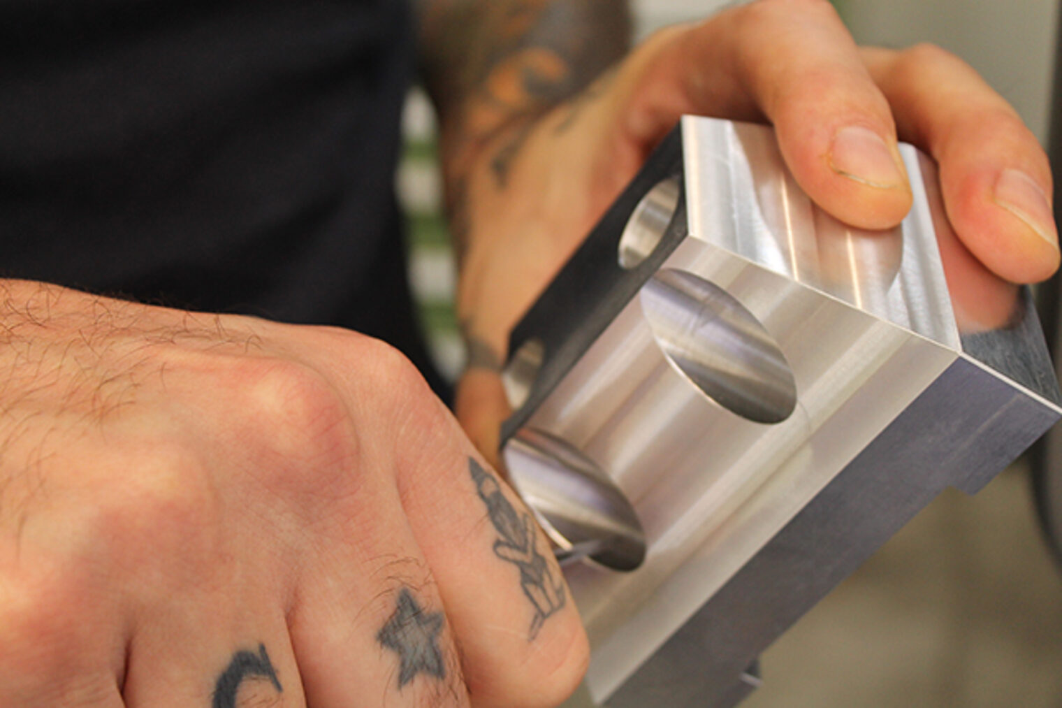 Entgraden eines CNC-gefrästen Metallteils durch Meisterschüler Teilnehmer beim Entgraden eines in der CNC-Maschine gefrästen Metallstücks im Meisterkurs Feinwerkmechanik in Aschaffenburg